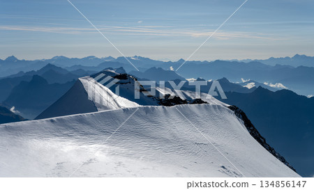 Hikers navigate the sharp, steep, and exposed summit ridge of Piz Palu in the Swiss Alps during a clear summer day, surrounded by breathtaking mountain views and glaciers. Hikers navigate the sharp, steep, and exposed summit ridge of Piz Palu in the Swiss Alps during a clear summer day, surrounded by breathtaking mountain views and glaciers. 134856147