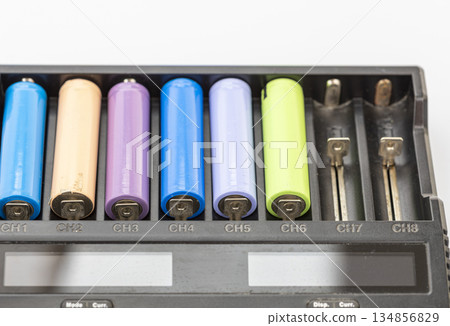 Close-up of a black battery charger with several colorful rechargeable batteries inserted in channels 1 through 6 134856829