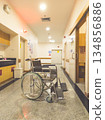 Empty wheelchair in a modern hospital corridor with clean interior and bright lighting. Healthcare and medical concept representing patient care, disability support, rehabilitation, emergency services 134856886