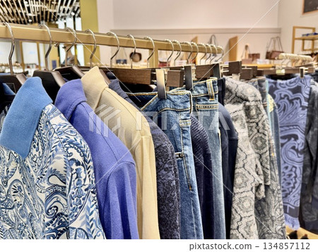 men's polo shirts and jeans are hanging on a hanger in a clothing store men's polo shirts and jeans are hanging on a hanger in a clothing store 134857112