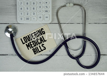 Lowering Medical Bills text with Stethoscope and calculator on wooden background Lowering Medical Bills text with Stethoscope and calculator on wooden background 134857644