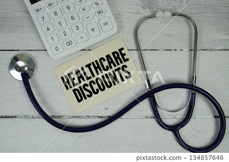 Healthcare Discounts text with Stethoscope and calculator on wooden background 134857646