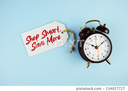 Shop Smart, Save More text on price tag with alarm clock on blue background Shop Smart, Save More text on price tag with alarm clock on blue background 134857727