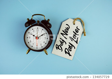 Buy Now Pay Later text on price tag with alarm clock on blue background Buy Now Pay Later text on price tag with alarm clock on blue background 134857729