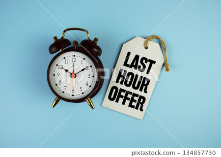 Last Hour Offer text on price tag with alarm clock on blue background 134857730