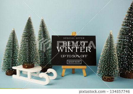 End of Year Sale 50% off text with easel and Christmas tree on blue background End of Year Sale 50% off text with easel and Christmas tree on blue background 134857746