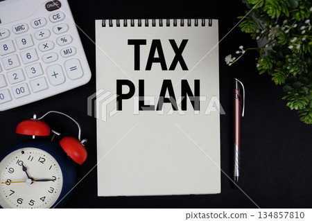 Tax Plan text with calculator with alarm clock on black background 134857810