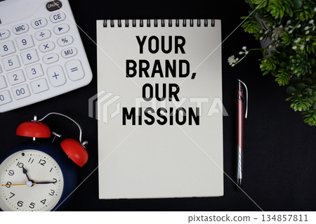 Your Brand, Our Mission text with calculator with alarm clock on black background Your Brand, Our Mission text with calculator with alarm clock on black background 134857811