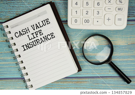 Cash Value Life Insurance text on notepad with magnifying glass and calculator on wooden background 134857829