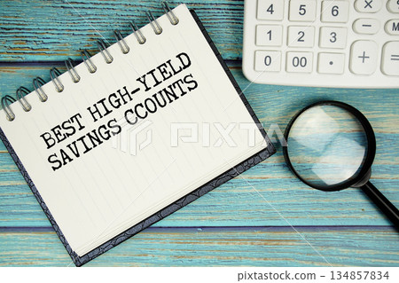 Best High-Yield Savings Accounts text on notepad with magnifying glass and calculator on wooden background 134857834