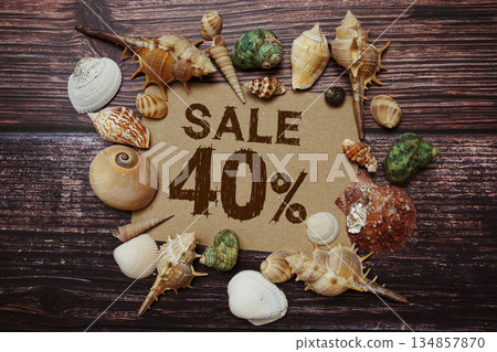 Sale 40% off sign decorated with seashells on a wooden background Sale 40% off sign decorated with seashells on a wooden background 134857870