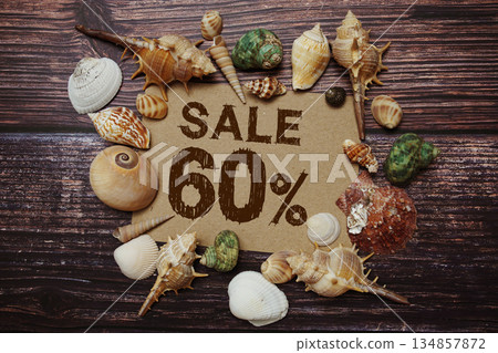 Sale 60% off sign decorated with seashells on a wooden background Sale 60% off sign decorated with seashells on a wooden background 134857872