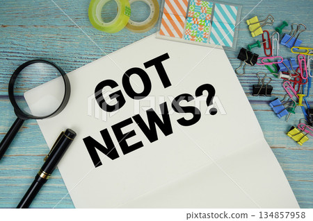 Got News? text on a paper surrounded by office supplies and magnifying glass on a blue wooden surface Got News? text on a paper surrounded by office supplies and magnifying glass on a blue wooden surface 134857958