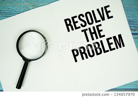 Resolve The Problem text written on notepad with magnifying glass flat lay on wooden background 134857970