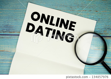 Online Dating text written on notepad with magnifying glass flat lay on wooden background Online Dating text written on notepad with magnifying glass flat lay on wooden background 134857976