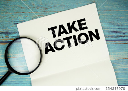 Take Action text written on notepad with magnifying glass flat lay on wooden background Take Action text written on notepad with magnifying glass flat lay on wooden background 134857978