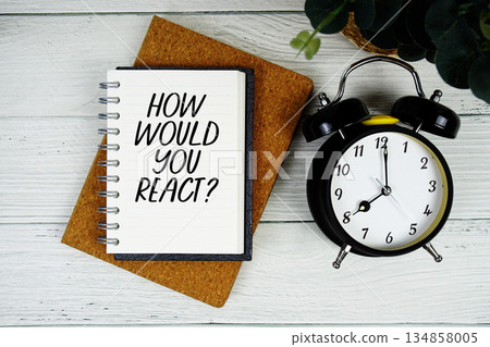 How Would You React? text written on notepad with alarm clock on wooden background How Would You React? text written on notepad with alarm clock on wooden background 134858005