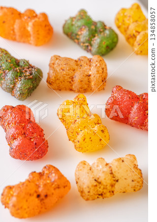 Colorful gummy bears with chili lime seasoning displayed on clean white plate 134858057