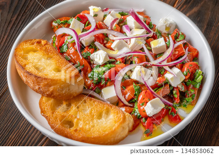 Roasted red pepper salad with feta red onion herbs and toasted crostini 134858062