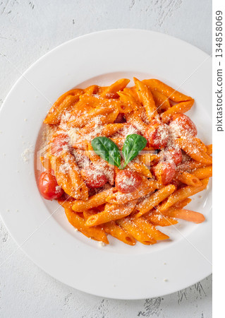 Penne pasta with roasted bell pepper emulsion cherry tomatoes Parmesan and herbs Penne pasta with roasted bell pepper emulsion cherry tomatoes Parmesan and herbs 134858069