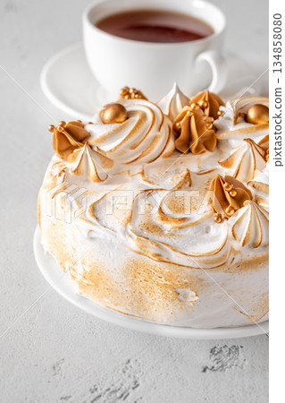 Madonna honey cake topped with toasted meringue and golden decorations flat lay 134858080