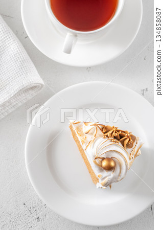 Slice of Medovik honey cake with toasted meringue and golden garnish 134858087