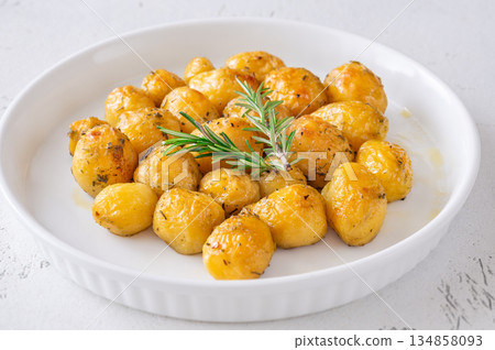 Oven baked baby potatoes seasoned with herbs served in white ceramic bowl 134858093