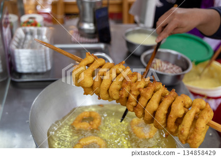 A woman is cooking picarones in a pan A woman is cooking picarones in a pan 134858429