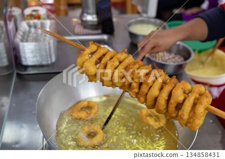 A woman is cooking picarones in a pan 134858431