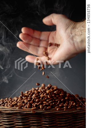 The freshly roasted coffee beans are poured into a basket. 134858736