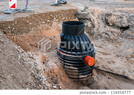 Underground plastic drainage inspection chamber installation at construction site amid ground works 134858777