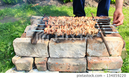 Appetizing shashlik outside. Cooking of pork meat. Barbecue lunch Appetizing shashlik outside. Cooking of pork meat. Barbecue lunch 134859220