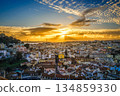 Amazing sunset over cityscape of Lisbon, Portugal, historic center, Tagus river, Sao Jorge castle with dramatic clouds, Ponte 25 de Abril or April 25th bridge silhouette, sunlight, colorful tiled 134859330