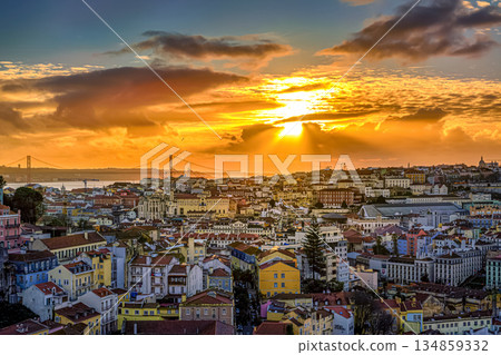 Beautiful sunset over cityscape of Lisbon, Portugal, historic center, Tagus river with dramatic clouds, famous Ponte 25 de Abril or April 25th bridge silhouette, sunlight, colorful tiled rooftops Beautiful sunset over cityscape of Lisbon, Portugal, historic center, Tagus river with dramatic clouds, famous Ponte 25 de Abril or April 25th bridge silhouette, sunlight, colorful tiled rooftops 134859332