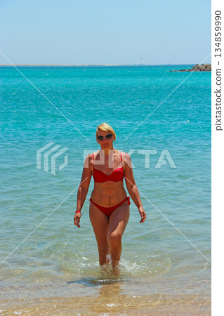 Pretty woman comsng out of sea during summer vacation Pretty woman comsng out of sea during summer vacation 134859990