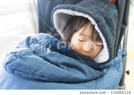 Japanese girl toddler wrapped in a sleeping bag in a stroller 134860116