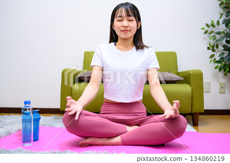 輕鬆坐姿，柔軟度好，年輕女子在家做瑜伽 134860219