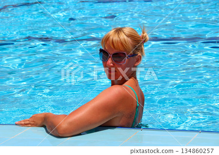 Attractive woman posing during relaxing in swimming pool during vacation 134860257