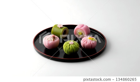 Minimalist, an assortment of colorful and delicate wagashi sweets, including a pink sakura-mochi and a green nerikiri, beautifully arranged on a black lacquer tray Minimalist, an assortment of colorful and delicate wagashi sweets, including a pink sakura-mochi and a green nerikiri, beautifully arranged on a black lacquer tray 134860265