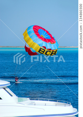 Man is fond of parasailing over Red Sea. Tropical resort in Egypt Man is fond of parasailing over Red Sea. Tropical resort in Egypt 134860300