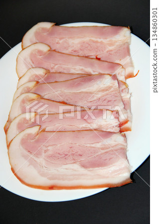 Sliced smoked meat on white plate. Food appetizer concept 134860301