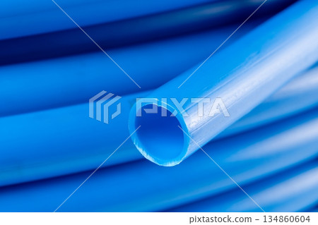 Close-up of a coiled blue plastic pipe Close-up of a coiled blue plastic pipe 134860604