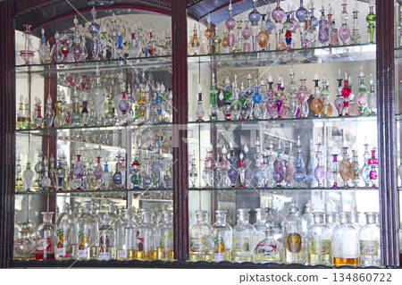 Figured glass retorts and colored bottles for aroma and perfume. Perfume shop 134860722