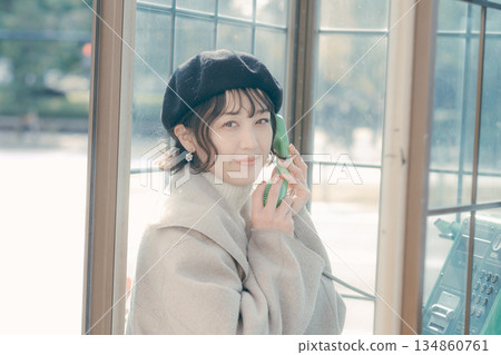 生活場景：一位三十多歲的女性在公用電話上交談 134860761
