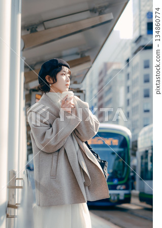 一位三十多歲的女性在車站月台上喝咖啡的生活場景 一位三十多歲的女性在車站月台上喝咖啡的生活場景 134860774
