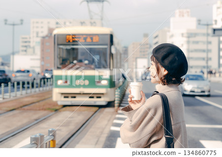 Lifestyle scene of a woman in her 30s drinking coffee on the station platform 134860775