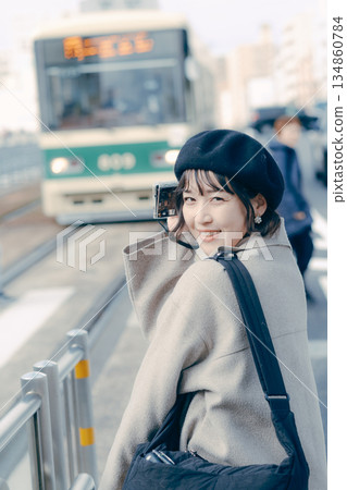 Portrait of a woman in her 30s smiling and holding a camera Portrait of a woman in her 30s smiling and holding a camera 134860784