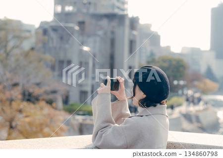 一位三十多歲的女子在旅遊景點用智慧型手機拍照。 一位三十多歲的女子在旅遊景點用智慧型手機拍照。 134860798