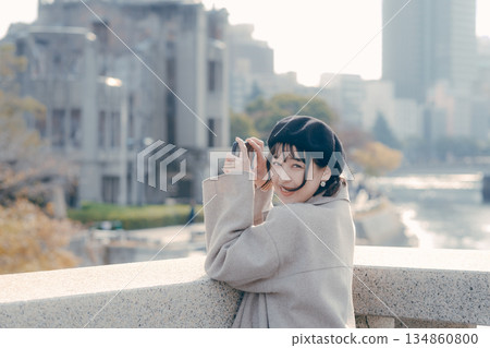 A woman in her 30s taking photos with her smartphone at a tourist spot A woman in her 30s taking photos with her smartphone at a tourist spot 134860800