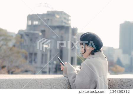 A woman in her 30s using her smartphone to check information at a tourist spot 134860812